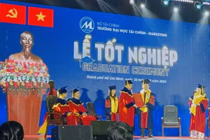 Tân Tiến sĩ Lê Bá Thường (bên phải) nhận bằng trong lễ tốt nghiệp. 