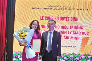 TS Nguyễn Viết Lộc - Vụ trưởng Vụ Tổ chức cán bộ, Bộ GD&ĐT trao Quyết định và tặng hoa chúc mừng cho tân Phó hiệu trưởng.