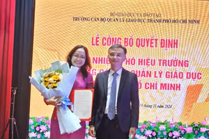 TS Nguyễn Viết Lộc - Vụ trưởng Vụ Tổ chức cán bộ, Bộ GD&ĐT trao Quyết định và tặng hoa chúc mừng cho tân Phó hiệu trưởng.