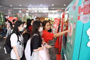 Sinh viên tham gia sự kiện thực hiện thử việc bỏ chai nhựa vào máy thu gom.