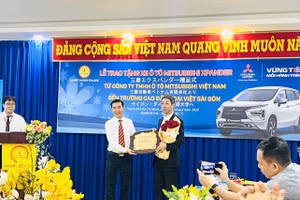 TS Lê Lâm - Hiệu trưởng Trường Cao đẳng Đại Việt Sài Gòn(trái) gửi hoa cảm ơn đại diện Công ty TNHH ô tô Mitsubishi Việt Nam.