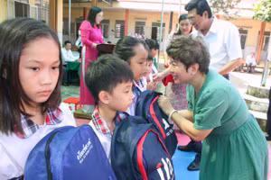 Nhà báo Dương Thanh Hương - Phó Tổng biên tập Báo Giáo dục và Thời đại và ông Trần Thanh Bình- Giám đốc Sở GD&ĐT TP Cần Thơ trao quà cho học sinh Trường Tiểu học Phú Hữu 4 (huyện Châu Thành, tỉnh Hậu Giang) 