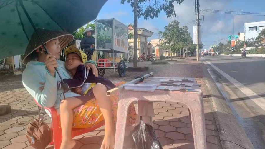 Một người bán vé số ngoài lề đường ở TP Cà Mau.