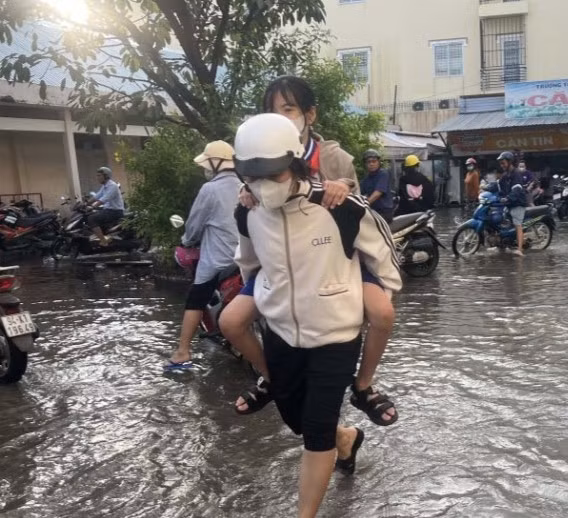 Phụ huynh cõng con em vào lớp thời điểm triều cường.