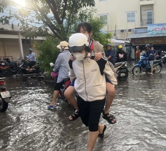 Phụ huynh cõng con em vào lớp thời điểm triều cường.