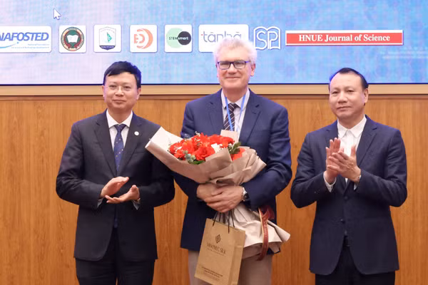 Lãnh đạo Trường ĐH Sư phạm Hà Nội tặng hoa chuyên gia quốc tế đến tham dự hội thảo.