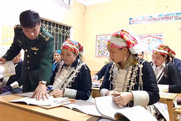 Trung tá Đinh Thái Đạt hướng dẫn học viên tại lớp học xóa mù chữ. 