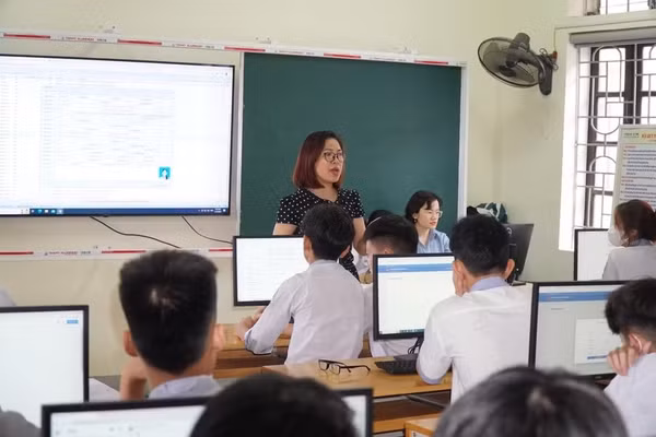 Giáo viên tại phường Trường Vinh, Nghệ An hỗ trợ học sinh đăng ký tuyển sinh trực tuyến. Ảnh: Hồ Lài