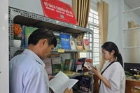 Người dân đọc sách trong thời gian chờ tại Trung tâm Phục vụ hành chính công xã Thạnh Hòa (TP Cần Thơ).