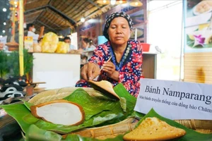 Nghệ nhân biểu diễn món bánh truyền thống của đồng bào Chăm tại tỉnh An Giang. Ảnh: Tạ Quang.