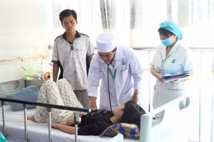 Bác sĩ CKII. Nguyễn Huỳnh Nhật Trường thăm khám cho bệnh nhi mắc sốt xuất huyết. Ảnh: Yến Phương.