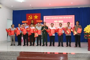 Đại tá Cao Minh Tâm, Phó Chính ủy Bộ Chỉ huy Quân sự tỉnh An Giang trao Quyết định cho các bí thư xã, phường. Ảnh: Phương Vũ.