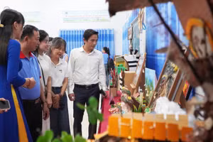 Các đại biểu tham quan khu vực trưng bày các sản phẩm tái chế từ rác thải, giấy vụn. Ảnh: Yến Phương.