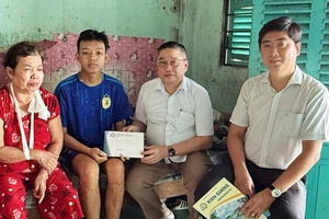 TS Nguyễn Hữu Thọ, Bí thư Đảng ủy, Chủ tịch Hội đồng Trường Đại học Kiên Giang trao tiền hỗ trợ sinh viên Tuấn Anh và gia đình.