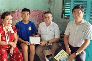 TS Nguyễn Hữu Thọ, Bí thư Đảng ủy, Chủ tịch Hội đồng Trường Đại học Kiên Giang trao tiền hỗ trợ sinh viên Tuấn Anh và gia đình.