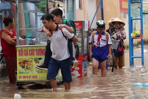 Học sinh và phụ huynh vất vả di chuyển khi triều cường dâng cao.