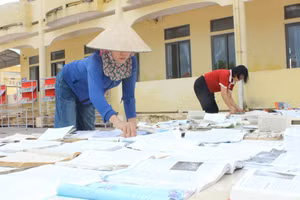 Giáo viên Trường THCS Sơn Lộc phơi sách sau bão.