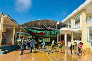 Lực lượng chức năng hỗ trợ dọn dẹp trường học sau mưa lũ.