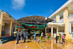 Lực lượng chức năng hỗ trợ dọn dẹp trường học sau mưa lũ.