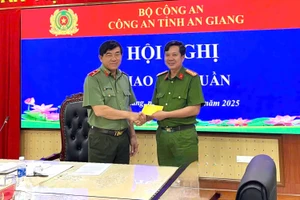Thiếu tướng Nguyễn Văn Hận trao tặng 20 triệu đồng cho Thượng tá Trần Minh Khánh, Trưởng Công an đặc khu Thổ Châu đại diện cán bộ, chiến sĩ đơn vị tiếp nhận. Ảnh: Tiến Dũng.