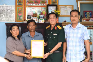 Đại tá Cao Minh Tâm, Phó Chính ủy Bộ Chỉ huy Quân sự tỉnh An Giang bàn giao nhà tình nghĩa cho gia đình ông Huỳnh Văn Liêu. Ảnh: Phương Vũ.