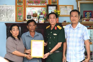 Đại tá Cao Minh Tâm, Phó Chính ủy Bộ Chỉ huy Quân sự tỉnh An Giang bàn giao nhà tình nghĩa cho gia đình ông Huỳnh Văn Liêu. Ảnh: Phương Vũ.