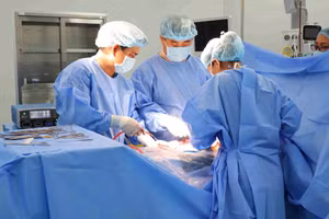 Các bác sĩ thực hiện phẫu thuật bóc tách nang buồng trứng cho bệnh nhi.