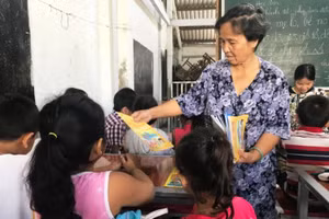 Cô giáo Son phát sách tập, dụng cụ học tập cho các em nhờ sự hỗ trợ của những học trò cũ.