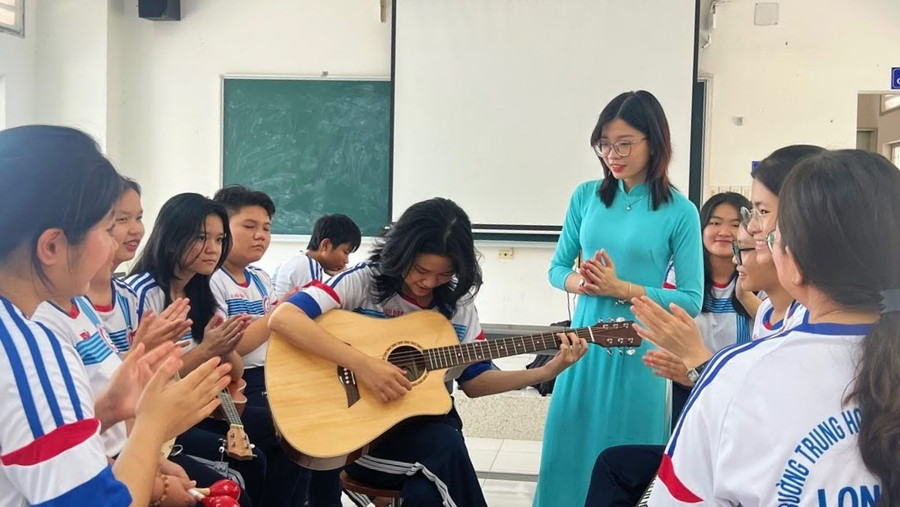 Cô Nguyễn Thị Thanh Thảo cùng học sinh học đàn Ghi - ta. Ảnh: NVCC. 