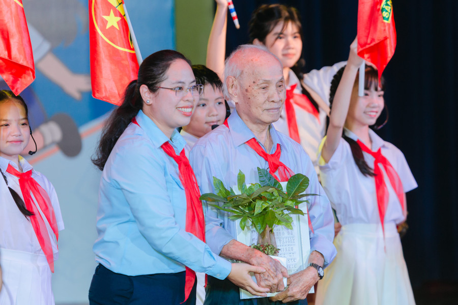 Chị Trịnh Thị Hiền Trân - Phó Bí thư Thành Đoàn, Chủ tịch Hội đồng Đội TPHCM cùng các thiếu nhi tặng quà tri ân nhạc sĩ Trương Quang Lục - tác giả ca khúc chủ đề công tác Đội năm học 2025 - 2026. Ảnh: Anh Thư. ht-7631-min.jpg