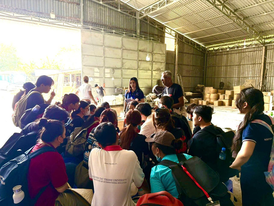 Giảng viên và sinh viên Trường Đại học Nguyễn Tất Thành học cách đan tre tại làng nghề Thái Mỹ. Ảnh: H.T. 02a32c8439d2b48cedc3.jpg