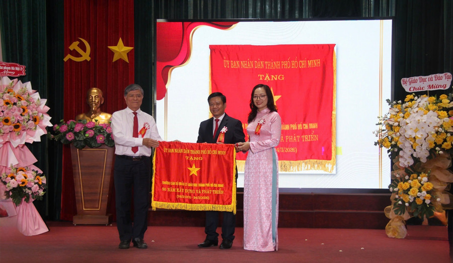 Ông Nguyễn Văn Hiếu - Giám đốc Sở GD&ĐT TPHCM trao cờ truyền thống của Uỷ ban Nhân dân TPHCM cho Trường Cán bộ Quản lý Giáo dục TPHCM. Ảnh: Thùy Linh. 