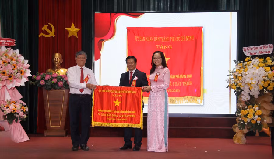 Ông Nguyễn Văn Hiếu - Giám đốc Sở GD&ĐT TPHCM trao cờ truyền thống của Uỷ ban Nhân dân TPHCM cho Trường Cán bộ Quản lý Giáo dục TPHCM. Ảnh: Thùy Linh. 