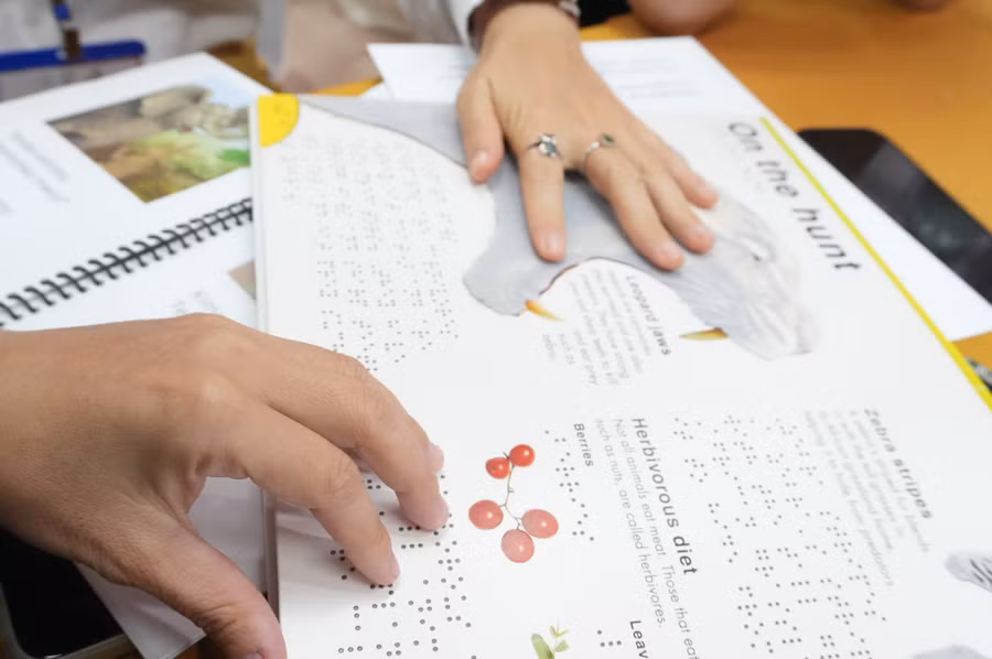 Học viên sử dụng sách chữ nổi. Ảnh: BTC. 