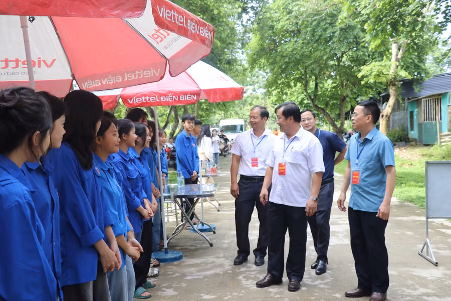 Ông Vừ A Bằng – Phó Chủ tịch UBND tỉnh (áo trắng hàng đầu) và ông Nguyễn Văn Đoạt – Giám đốc Sở GD&amp;ĐT (áo xanh ngoài cùng, tay phải) Điện Biên đã đi kiểm tra các điểm thi và động viên đội tình nguyện.