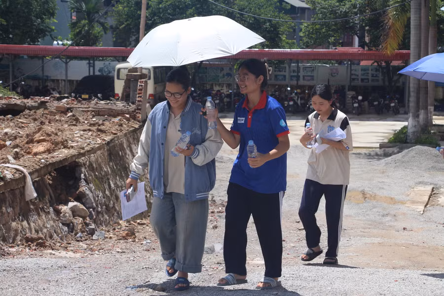 Tình nguyện viên tiếp nước, che nắng cho thí sinh bước vào môn thi toán.