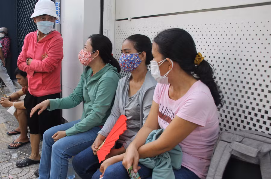 Sau khi chở con đến điểm thi, phụ huynh tại điểm thi THCS Trần Văn Ơn (quận 1) tìm những vị trí có thể tránh nắng để ngồi đợi.