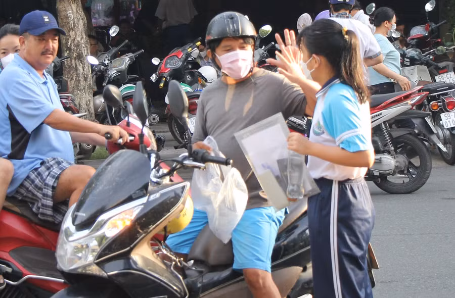 Phụ huynh động viên con gái tại điểm thi Trường THCS Phạm Hữu Lầu.