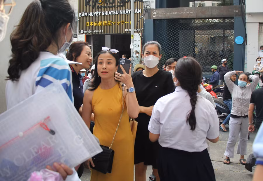 Phụ huynh tại điểm thi Trường THCS Trần Văn Ơn vui mừng khi con thông báo làm tốt bài thi.