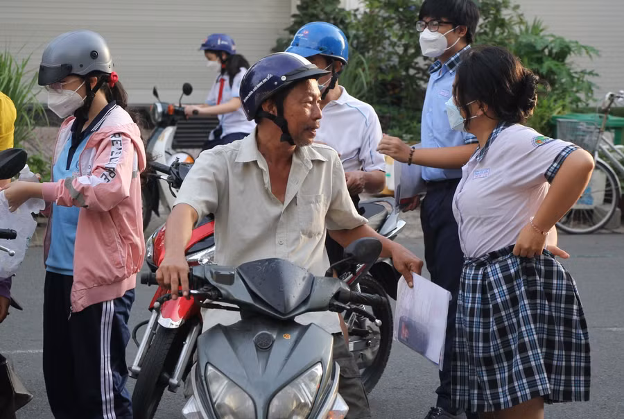 Phụ huynh động viên con sau khi kết thúc thi môn Toán tại điểm Trường THCS Phạm Hữu Lầu.