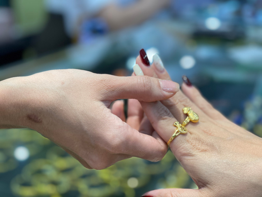 Nhẫn túi tiền - một trong những mẫu mã mới tại thị trường vàng Ngày vía Thần Tài được khách hàng ưa chuộng. "Năm nay tôi nhập hơn 100 nhẫn túi tiền nhưng sáng nay chỉ còn khoảng 20 cái dù giá cao hơn so với nhẫn tròn", chủ tiệm vàng Mai Xuân thông tin. Nhẫn túi tiền - một trong những mẫu mã mới tại thị trường vàng Ngày vía Thần Tài được khách hàng ưa chuộng. "Năm nay tôi nhập hơn 100 nhẫn túi tiền nhưng sáng nay chỉ còn khoảng 20 cái dù giá cao hơn so với nhẫn tròn", chủ tiệm vàng Mai Xuân thông tin.