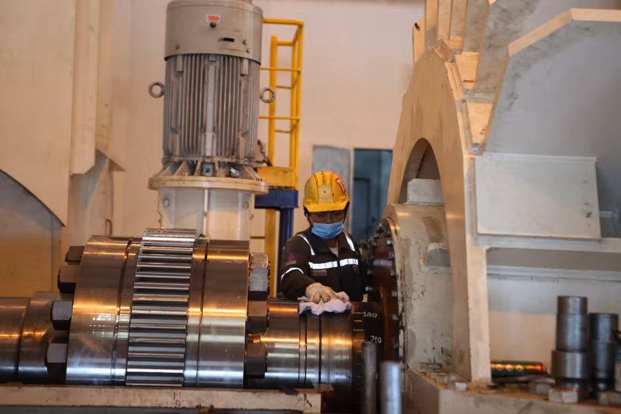 Nhân viên nhà thầu vệ sinh thiết bị sau khi đã lắp bu -lông kết nối giữa tua bin và máy phát.