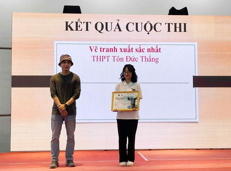 Họa sĩ Thắng Lê, thành viên Ban giám khảo trao giải cho Thí sinh Vũ Thị Bảo Quỳnh, đại diện đội thi vẽ của Trường THPT Tôn Đức Thắng. Ảnh: Xuân Định.