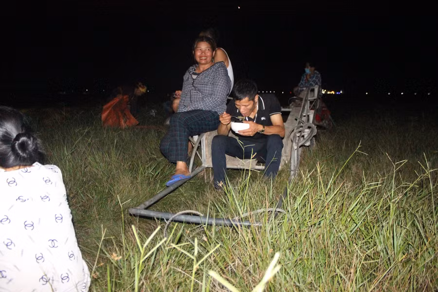 Tranh thủ ăn cơm trong khi máy đang gặt ruộng khác