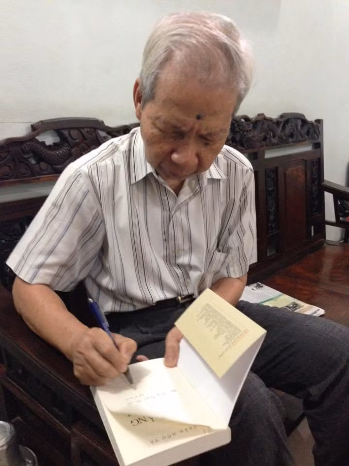 Nhà giáo Trần Hữu Tá ký tặng sách cho học trò cũ. Ảnh: Nguyễn Văn Cải.