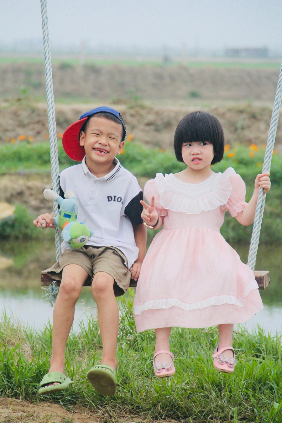 Đôi bạn nhỏ tạo dáng với xích đu. Đôi bạn nhỏ tạo dáng với xích đu.