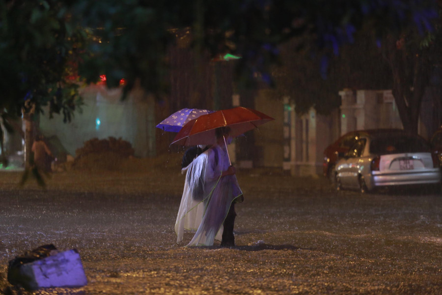 Phụ huynh đưa đón con từ các trung tâm tiếng Anh nằm trên đường ngập lụt buộc phải lội nước cõng hoặc bế con qua.