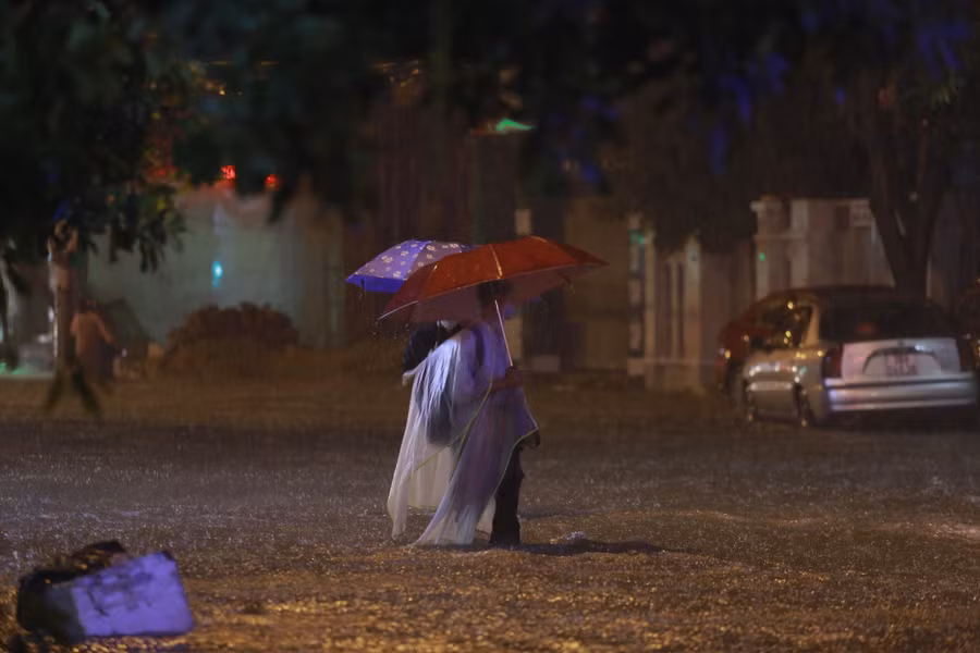 Phụ huynh đưa đón con từ các trung tâm tiếng Anh nằm trên đường ngập lụt buộc phải lội nước cõng hoặc bế con qua.