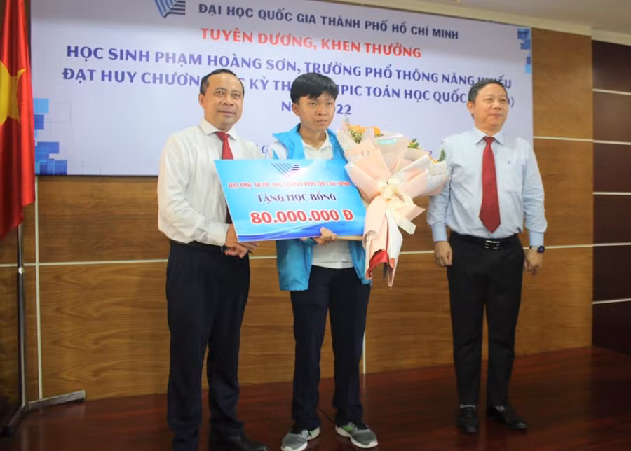 PGS.TS Vũ Hải Quân, Giám đốc Đại học quốc gia TPHCM và ông Dương Anh Đức, Phó Chủ tịch UBND TPHCM trao giấy khen và học bổng cho Phạm Hoàng Sơn.