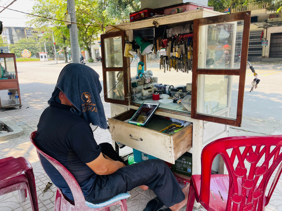 Một thợ sửa đồng hồ trên đường Nguyễn Công Trứ trùm khăn ướt &quot;giải nhiệt&quot; trên đầu...